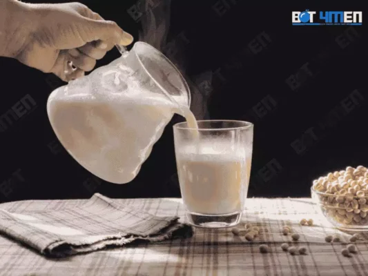 Một cách tay đang rót sữa đậu nành vào ly 
